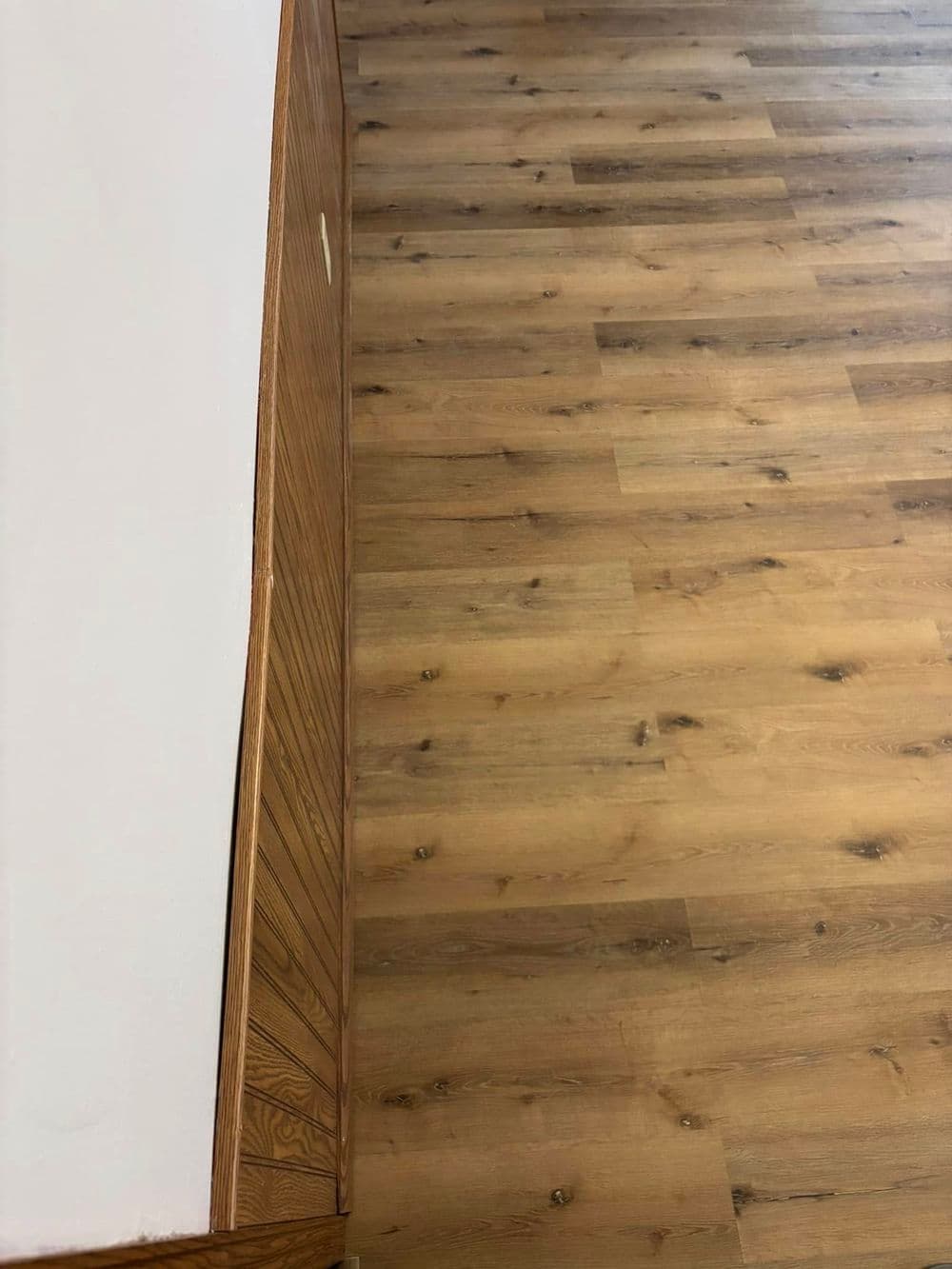 Wooden floor with light-colored planks and a wooden cabinet in a modern interior setting.